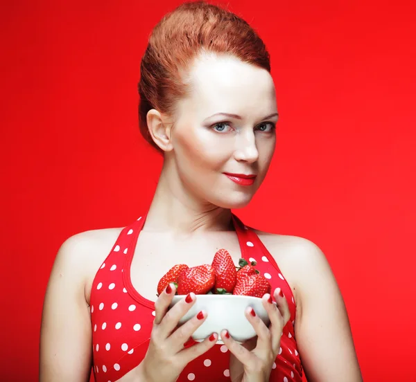 Frau mit Erdbeere auf rotem Hintergrund — Stockfoto