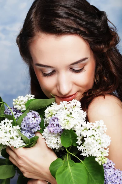 Mooie jongedame met lila bloemen — Stockfoto