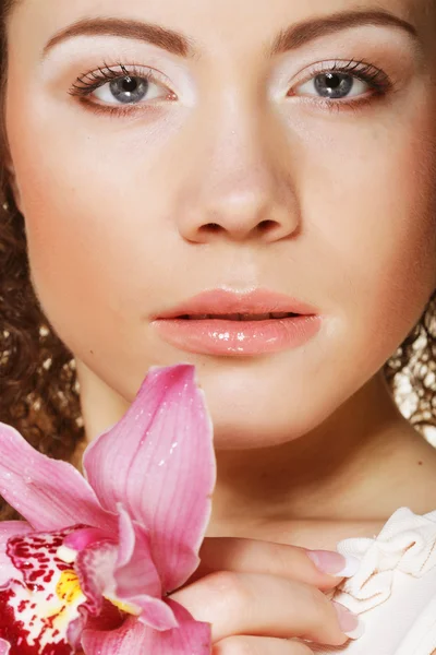 गुलाबी ऑर्किड के साथ सुंदर युवा महिला — स्टॉक फ़ोटो, इमेज