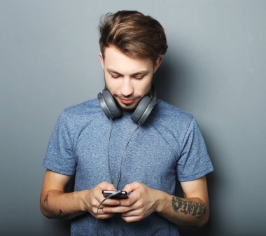 Kulaklıklar, boynunda giyen ve wh gülümseyen yakışıklı delikanlı