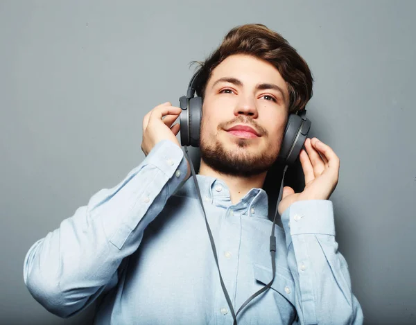 Beau jeune homme portant des écouteurs et écoutant de la musique . — Photo