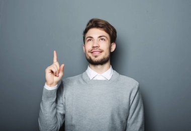 Genç ve yakışıklı bir işadamı parmağıyla işaret ediyor.