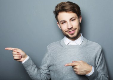 Genç ve yakışıklı bir işadamı parmağıyla işaret ediyor.