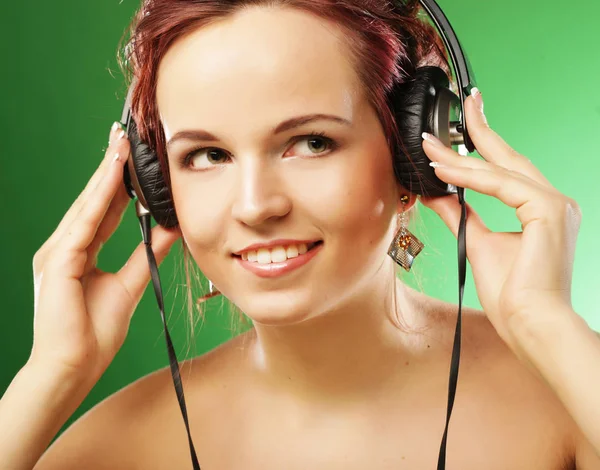 Ung, lykkelig kvinne som lytter til musikk med hodetelefoner – stockfoto