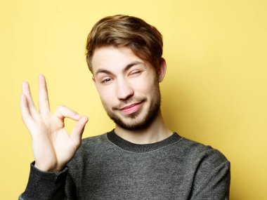 Mutlu yakışıklı adam baş parmağını kaldırıyor.