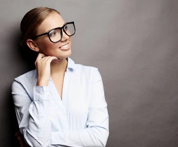 Heureux souriant jeune femme d'affaires dans des lunettes, sur fond gris backgr — Photo