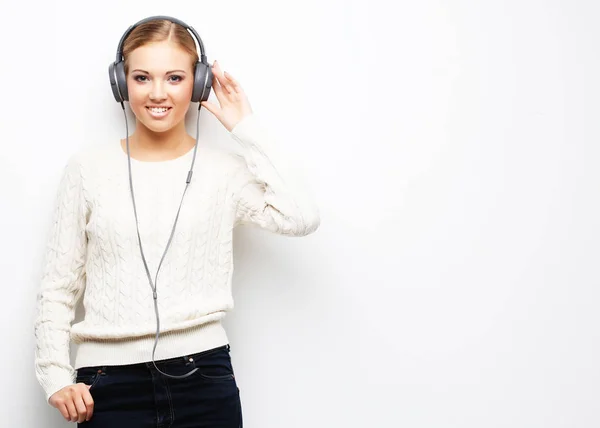 Mladá krásná žena poslouchat hudbu z sluchátka — Stock fotografie