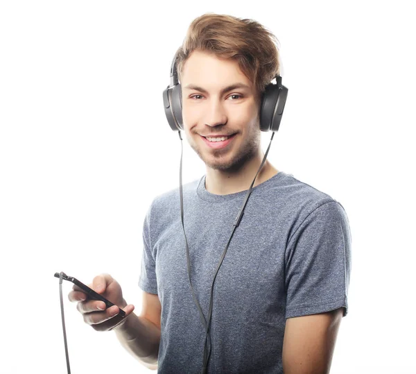 Hombre sosteniendo el teléfono móvil y lamiendo a la música sobre respaldo blanco — Foto de Stock
