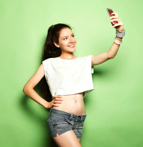 Okouzlující žena, takže selfie foto na smartphone přes zelené zpět — Stock fotografie