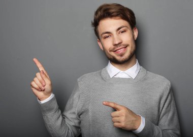 Genç ve yakışıklı bir işadamı parmağıyla işaret ediyor.