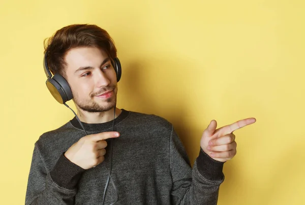 Bello uomo leccare per musica su sfondo giallo — Foto Stock