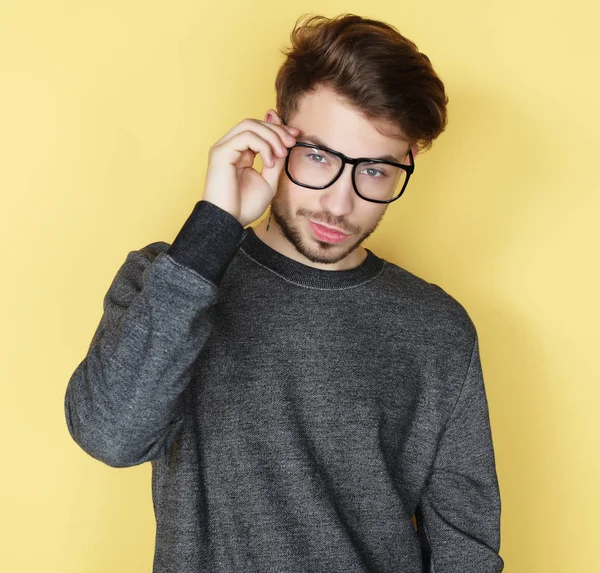 Man with great smile wearing fashion eyeglasses against  yellow — Stock Photo, Image