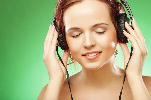 Молодая счастливая женщина слушает музыку с головными уборами — стоковое фото