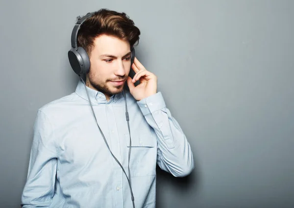 Beau jeune homme portant des écouteurs et écoutant de la musique . — Photo