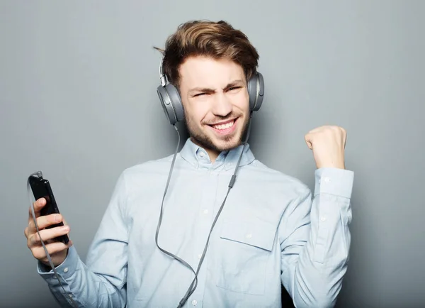 Jeune homme portant un casque et tenant un téléphone portable — Photo