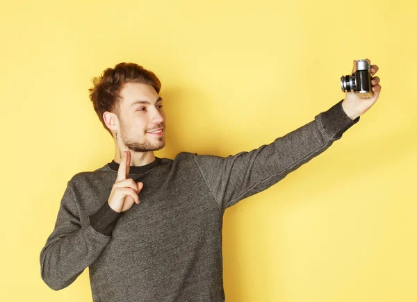 Sonriente hombre haciendo foto selfie sobre fondo amarillo — Foto de Stock