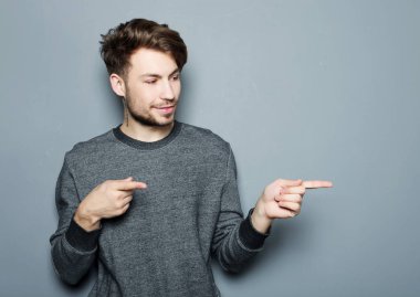 Genç ve yakışıklı bir işadamı parmağıyla işaret ediyor.