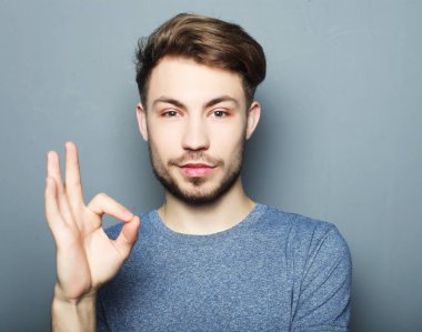 Yakışıklı adam mutlu gülümseme, ok hareket işareti ile elini tut