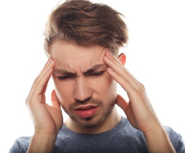 Genç iş adamı kafasına dokunuyor ve gözlerini kapalı tutuyor.