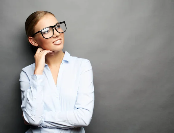 Geschäftsfrau mit Brille vor grauem Hintergrund — Stockfoto