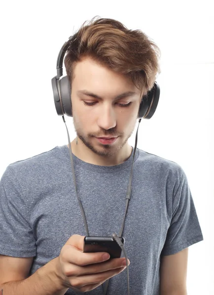 Homem segurando telefone celular e lambendo a música sobre backg branco — Fotografia de Stock