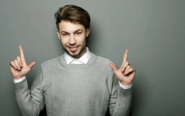 Ein junger und gutaussehender Geschäftsmann zeigt mit dem Finger nach oben — Stockfoto