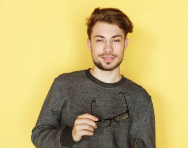 Gülümseyen, stüdyo çekim gözlüklü genç trendy adam