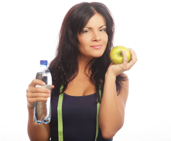 Modelo de fitness femenino sosteniendo una botella de agua y manzana verde — Foto de Stock