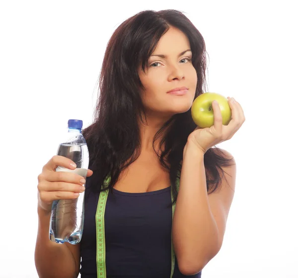 Modelo de fitness femenino sosteniendo una botella de agua y manzana verde — Foto de Stock