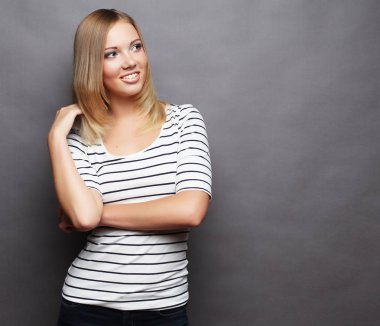 Genç gülümseyen güzel kadın. Gri arka plan üzerinde.