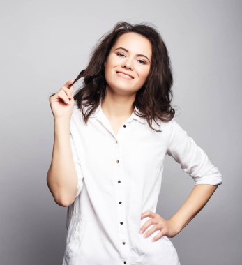 Genç sevimli gülümseyen esmer kız beyaz arka plan üzerinde