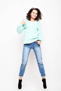 Gülümseyen genç bir kadın beyaz arka planda havada zıplıyor