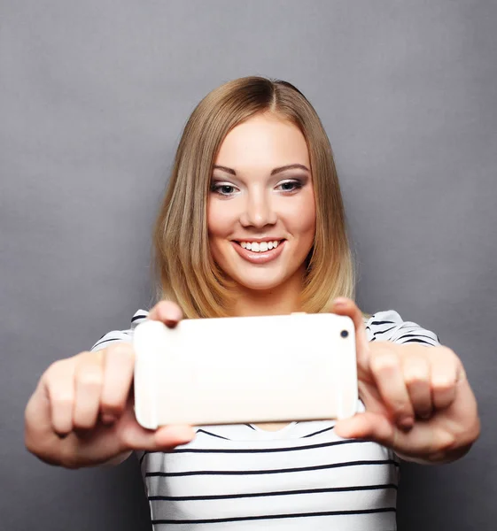 Donna elegante fare foto selfie su smartphone sopra zaino grigio — Foto Stock