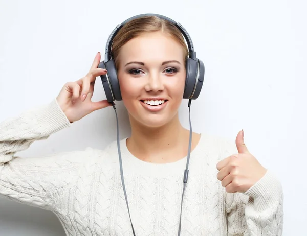 Young beautiful woman listening the music from headphones — Stock Photo, Image