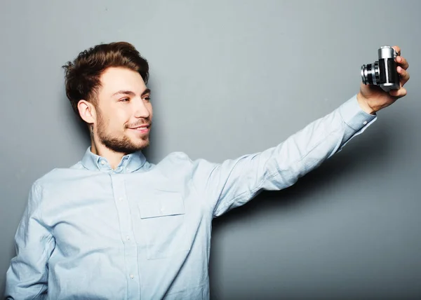 Guapo joven sosteniendo la cámara y haciendo selfie — Foto de Stock