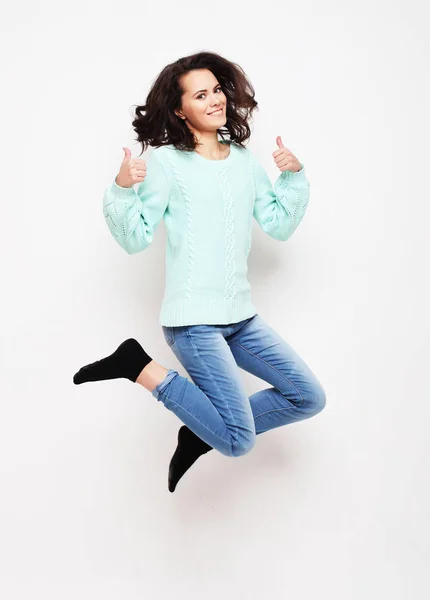 Sorrindo jovem mulher pulando no ar sobre fundo branco — Fotografia de Stock