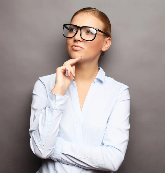 Mujer de negocios en gafas sobre fondo gris — Foto de Stock