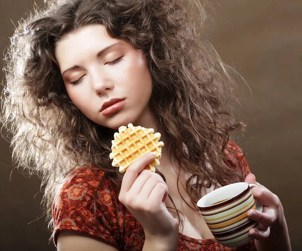 Jonge vrouw met koffie en koekjes — Stockfoto