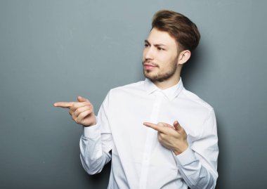 Genç ve yakışıklı bir işadamı parmağıyla işaret ediyor.