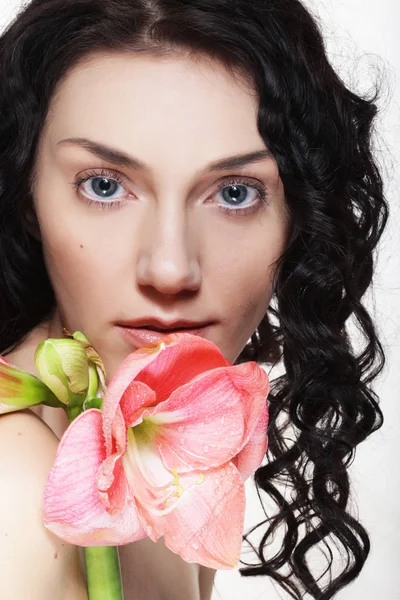 Joven hermosa mujer con grandes flores de color rosa — Foto de Stock