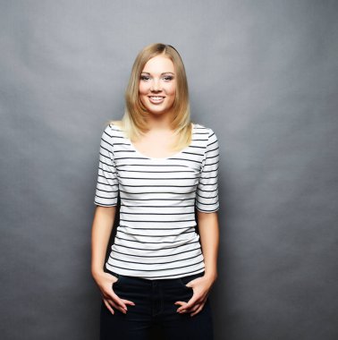 Genç gülümseyen güzel kadın. Gri arka plan üzerinde.