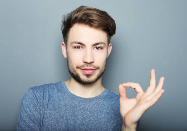 Yakışıklı adam mutlu gülümseme, ok hareket işareti ile elini tut