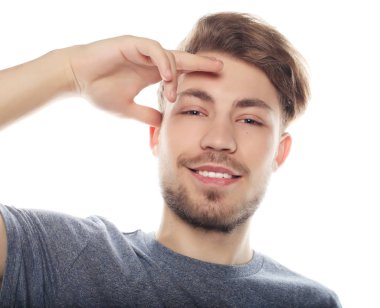 Mutlu gülümseyen adam beyaz arka planda izole edilmiş kameraya bakıyor.