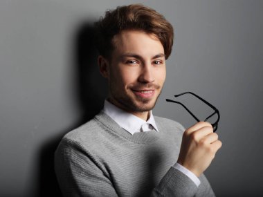 Gülümseyen, stüdyo çekim gözlüklü genç trendy adam