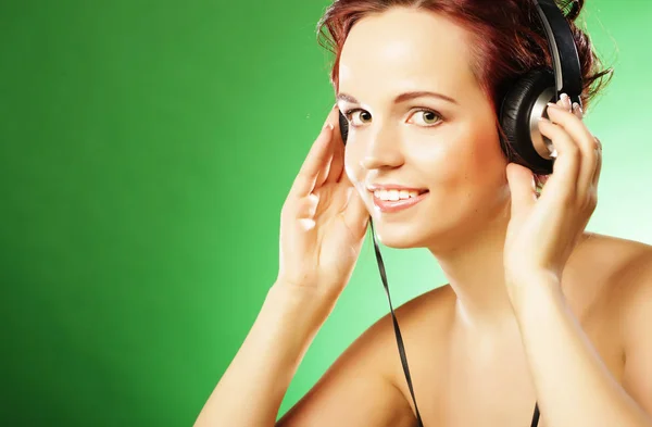 Молодая счастливая женщина слушает музыку с головными уборами — стоковое фото
