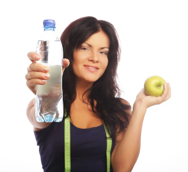 Female fitness model holding a water bottle and green apple — Stock Photo, Image