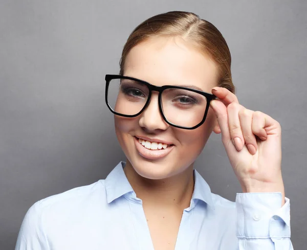 Mujer de negocios en gafas sobre fondo gris — Foto de Stock