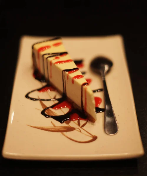 Cheesecake med choklad sås på en vit platta — Stockfoto