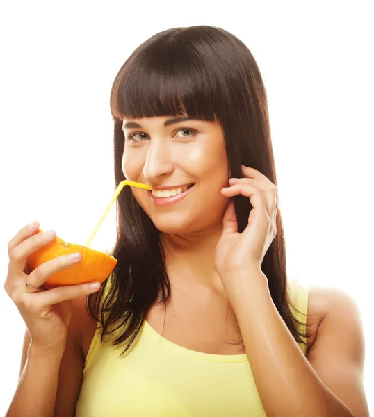 Hermosa mujer bebiendo jugo de naranja con paja — Foto de Stock