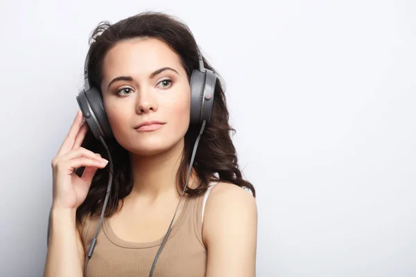 Estilo de vida e conceito de pessoas: Mulher jovem com fones de ouvido liste — Fotografia de Stock